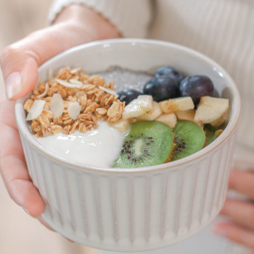 Petit-déjeuner équilibré à base de granola bio, yaourt, kiwi, myrtilles et banane pour jeunes mamans