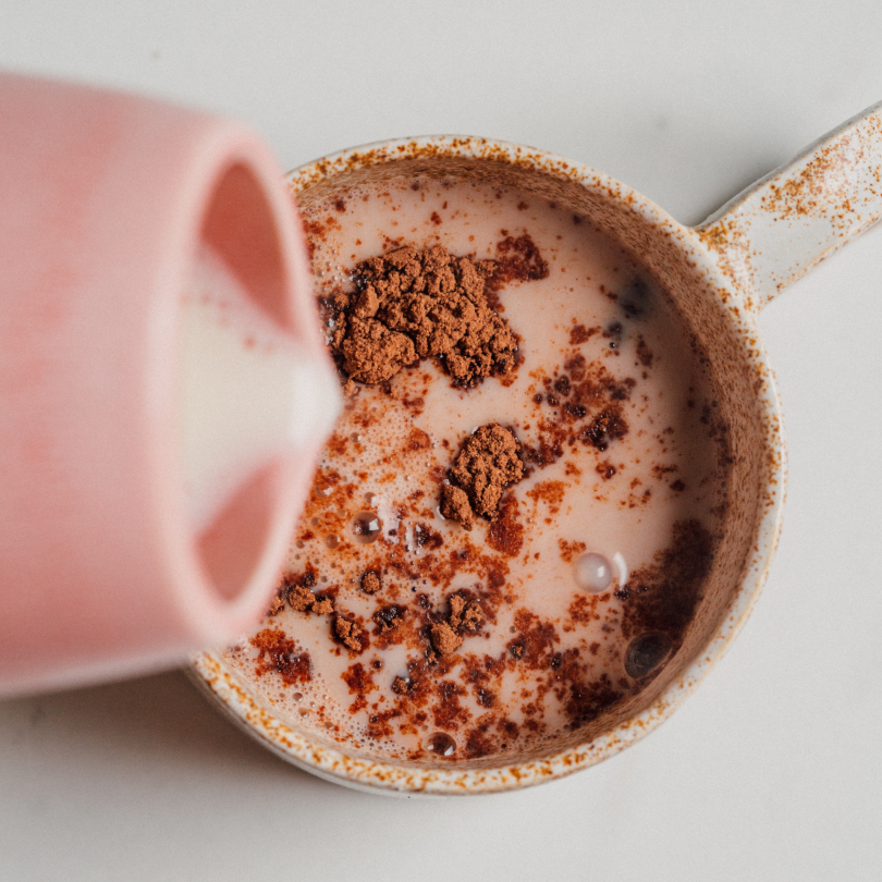 Tasse de boisson chaude au cacao bio nümorning versée dans une tasse rose