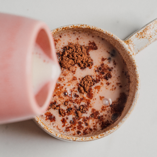 Tasse de boisson chaude au cacao bio nümorning versée dans une tasse rose