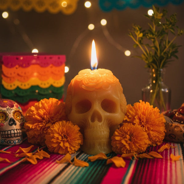Skull-shaped candle with orange marigold flowers on a colorful tablecloth. Skull-shaped candle, día de muertos candle