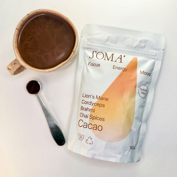 SOMA product packaging with a cup of cacao and spoon on a light background