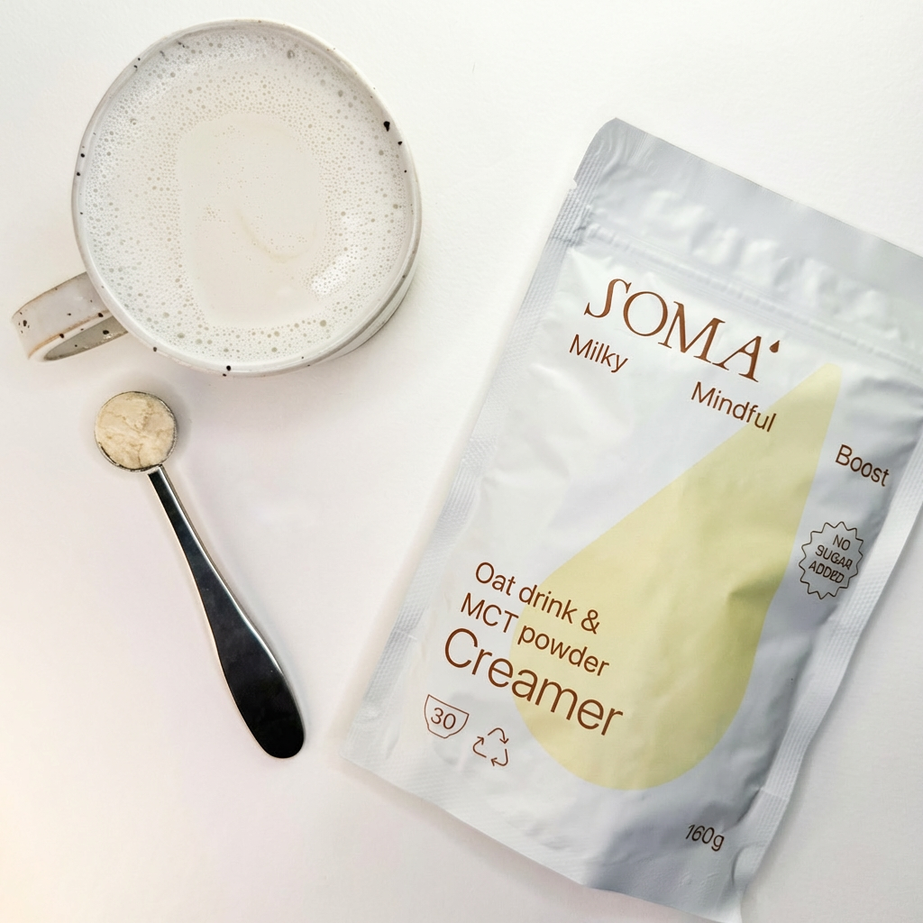 SOMA Milky Mindful Creamer package with a cup of oat drink and MCT powder on a white background