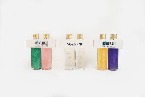 Rows of glittery nail polish bottles in green, pink, white with gold caps and white packaging in a bright display.