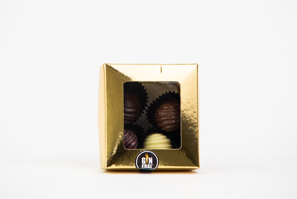 Gold gift box with a clear window showing assorted chocolates.