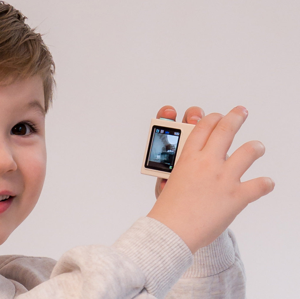 Otrok uporablja Hoppstar otroški digitalni fotoaparat Popcorn Breeze za fotografiranje.