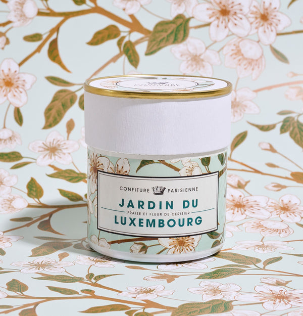 Pot Fraise Fleur de Cerisier x Jardin du Luxembourg devant un papier peint à branches de cerisier en fleurs