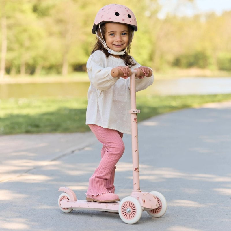 Otrok nosi Little Dutch čelado Fairy Floral pri vožnji