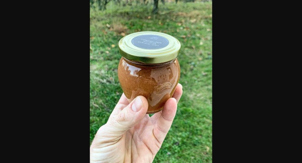 Izvirna fotografija marmelade iz kutine s cimetom Butul v roki na travniku