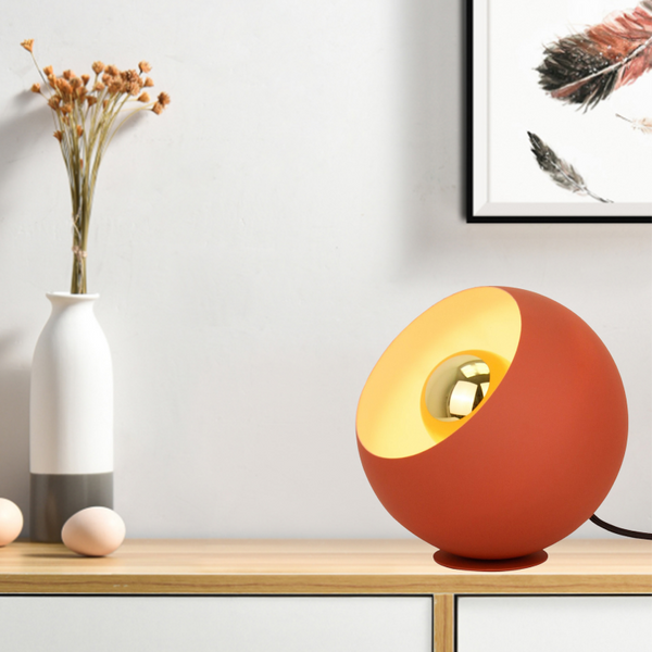 De rode Occhio tafellamp voegt een speelse touch toe aan elk interieur. Perfect voor een gezellig leeshoekje of bureau.