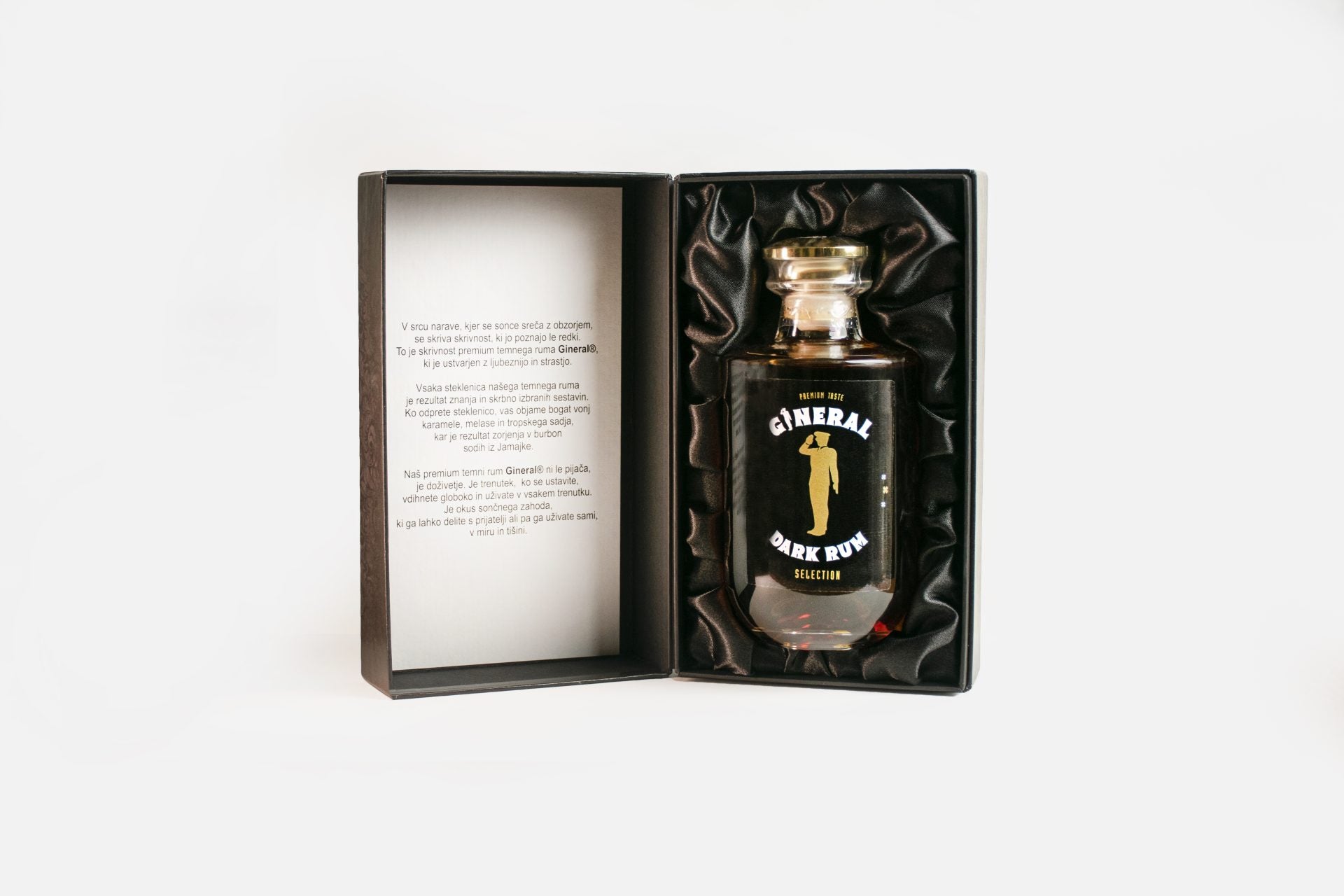 Open presentation box with a bottle of GINERAL Dark Rum nestled in black satin ink.