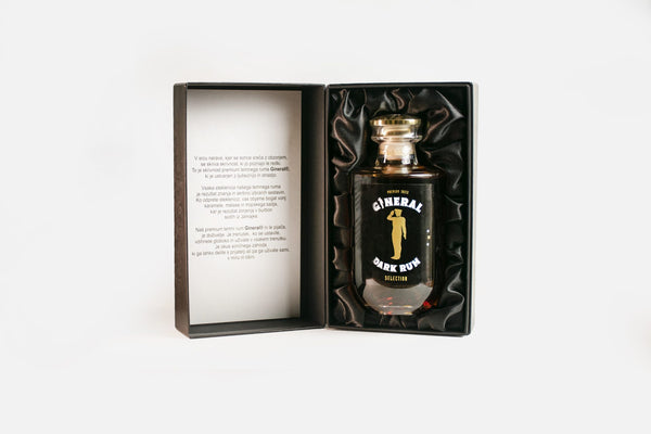Open presentation box with a bottle of GINERAL Dark Rum nestled in black satin ink.