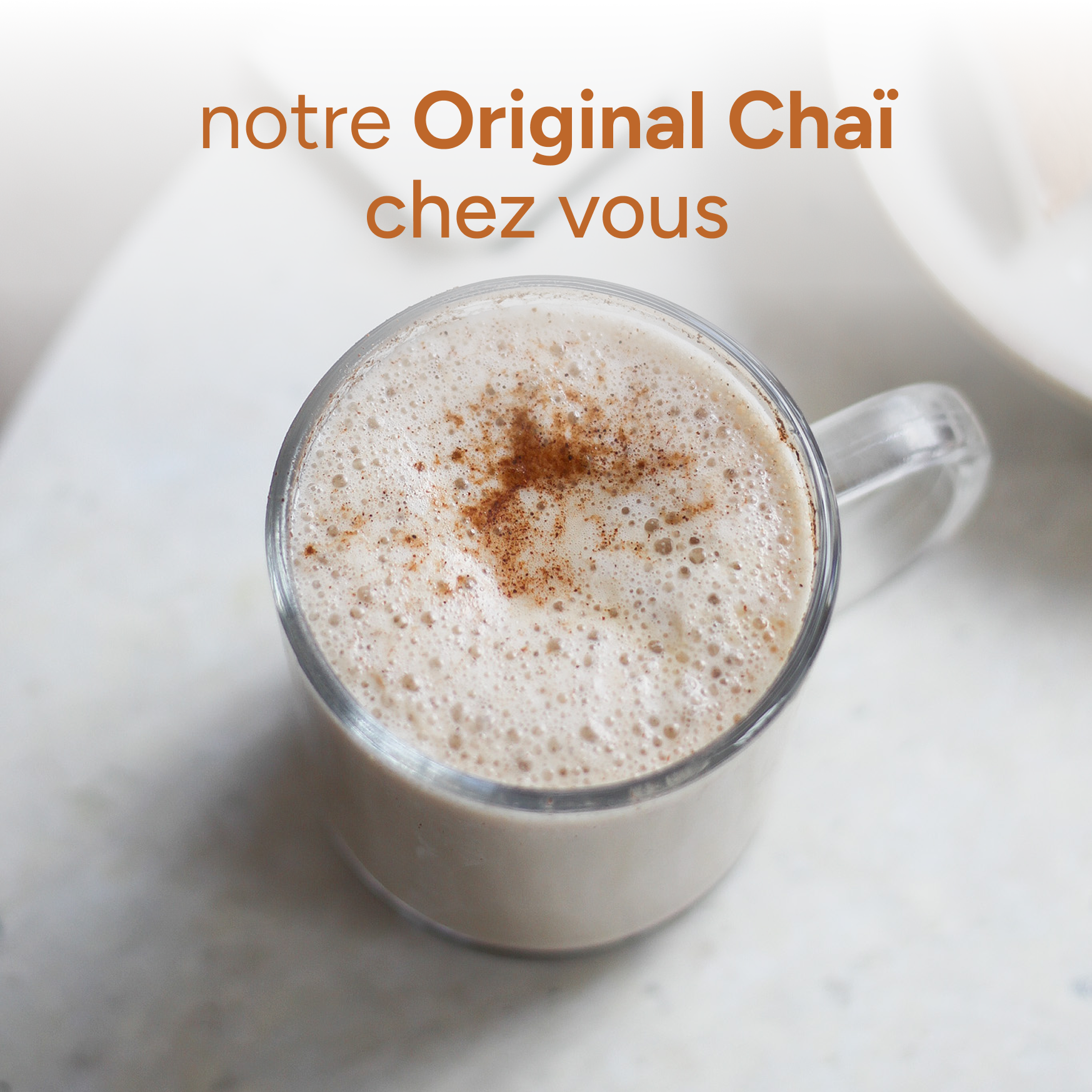 Verre de chaï latte onctueux, saupoudré d'épices, préparé à partir de l'Original Chaï de nümorning