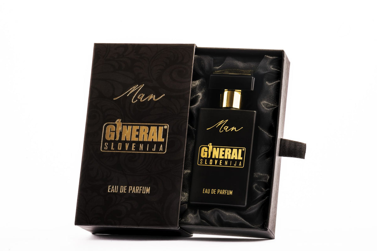 Open black gift box lined with satin reveals a black perfume bottle with gold text reading 'General Slovenija' and 'Man'.