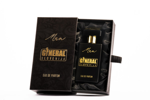 Open black gift box lined with satin reveals a black perfume bottle with gold text reading 'General Slovenija' and 'Man'.