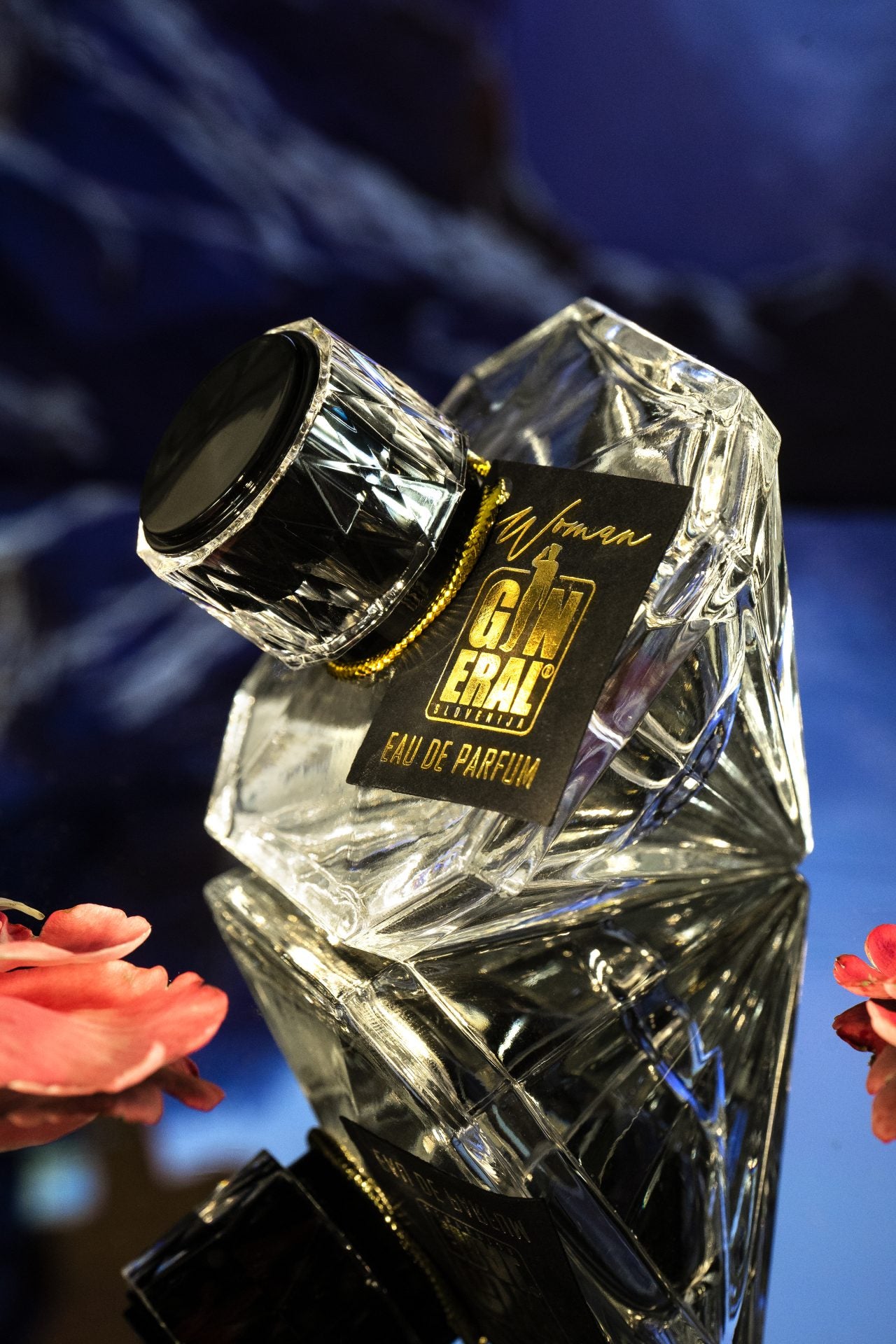 Faceted crystal perfume bottle with a black tag reading 'Eau de Parfum' and a gold cord.
