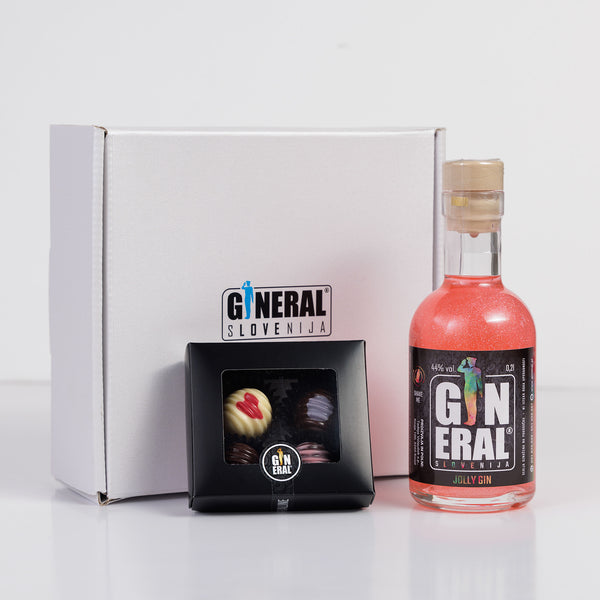Gin bottle labeled General Slovenija beside a black box of chocolates in a white gift box backdrop