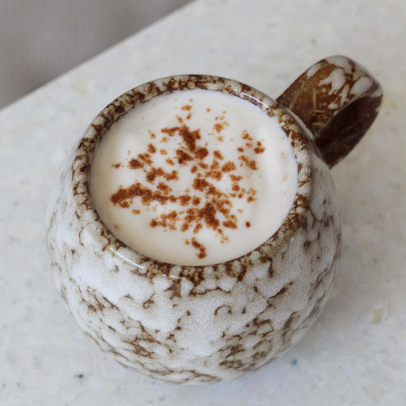 Mug de chaï épicé, préparé à partir des épices chaï nümorning, avec de la cannelle en poudre sur la mousse
